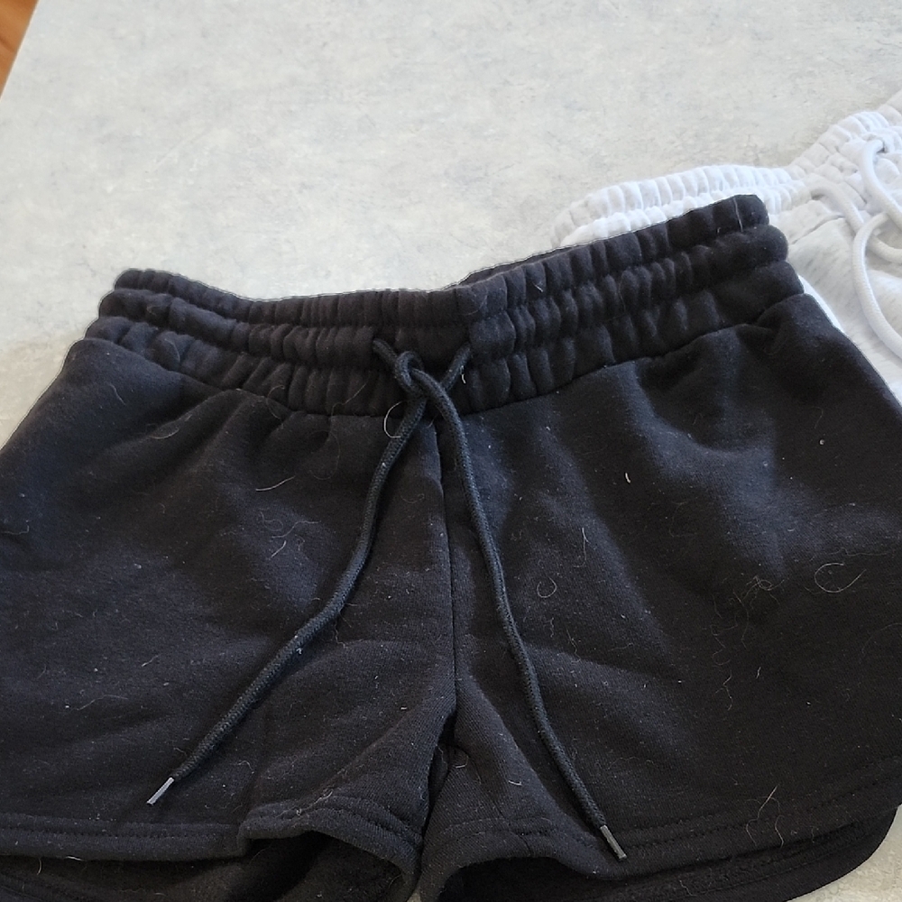 two white/grayish and black pairs of women's sweatshorts